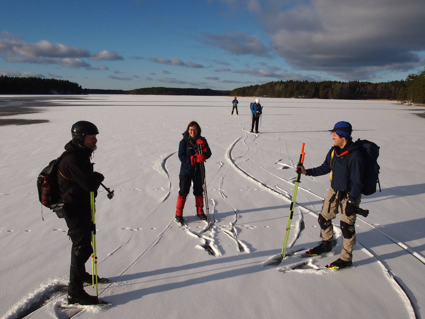 En gruppe som står på isen å prater sammen.