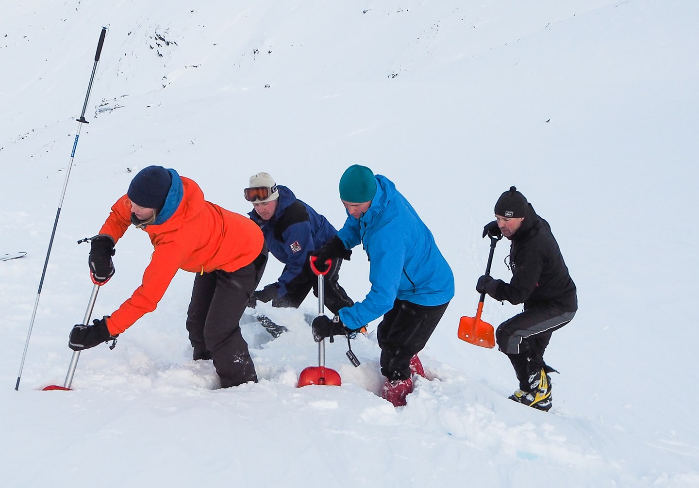 4 personer i V form som graver etter å ha gjort funn med søkestang