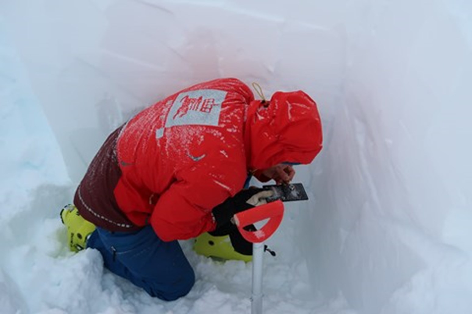 NVE-ansatt undersøker en snøprofil.